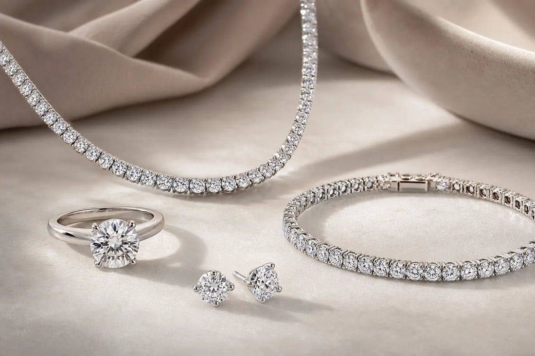 Lab grown diamond ring, tennis necklace, tennis bracelet, and stud earrings arranged on a neutral surface