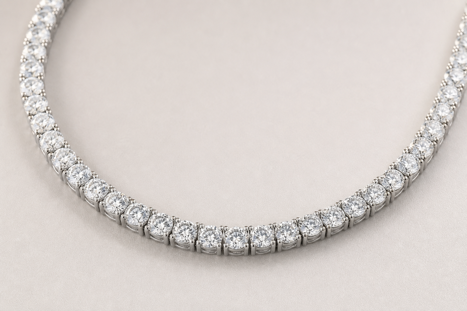 Natural diamond tennis necklace in white gold arranged in a curve on a light background