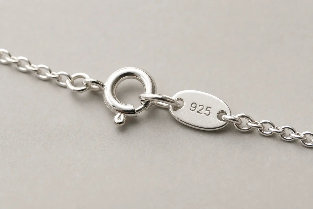 Close-up of a sterling silver necklace clasp with a 925 stamp