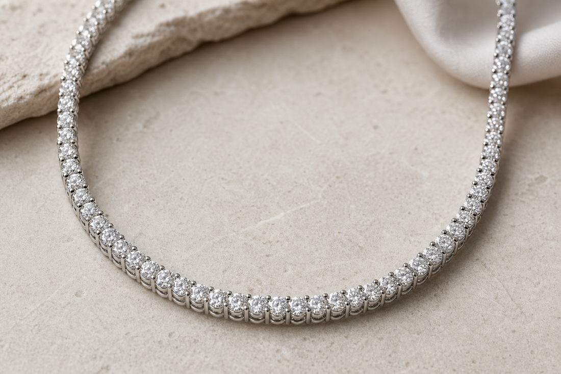 Diamond tennis necklace displayed in a curved shape on a neutral surface.